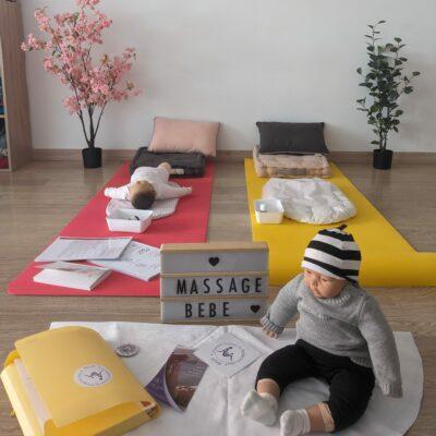 Installation d'un atelier massage bébé avec des tapis au sol, des poupons de massage